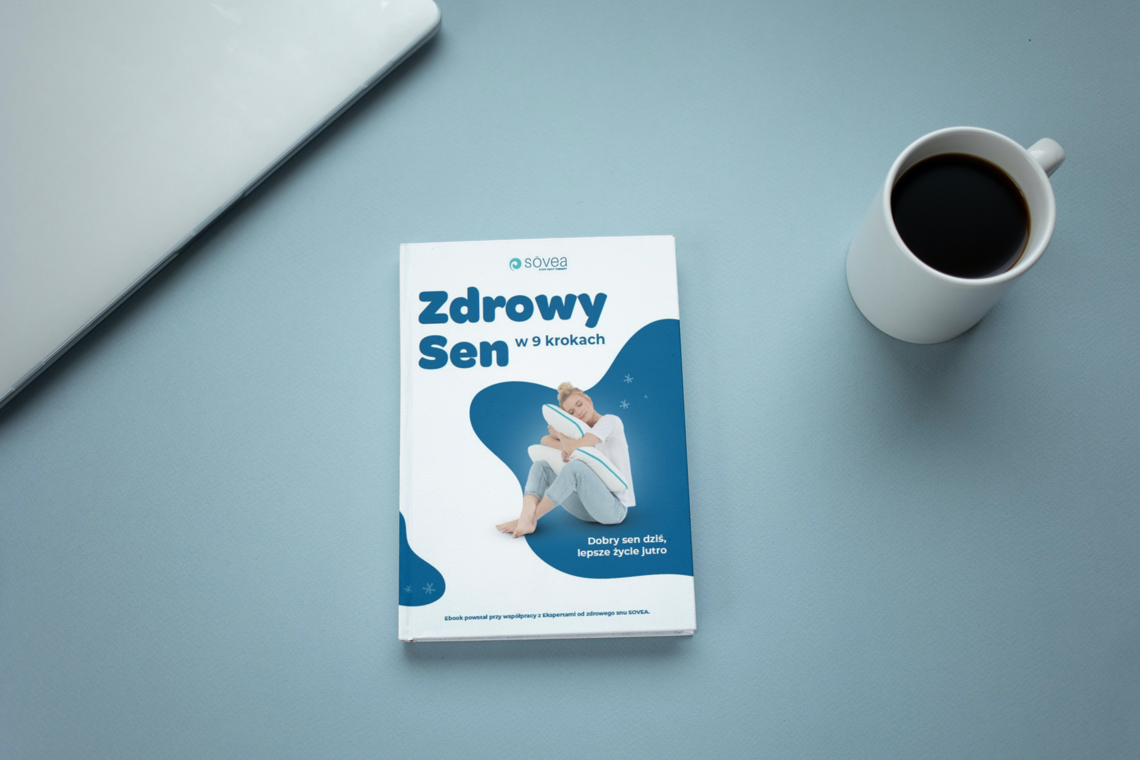 Book beside the cup of coffee_Zdrowy Sen w 9 krokach okładka